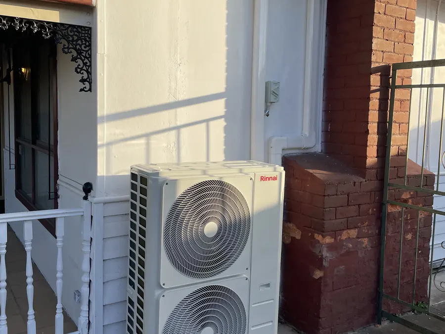 Rinnai outdoor condenser unit installed beside a period home in Melbourne